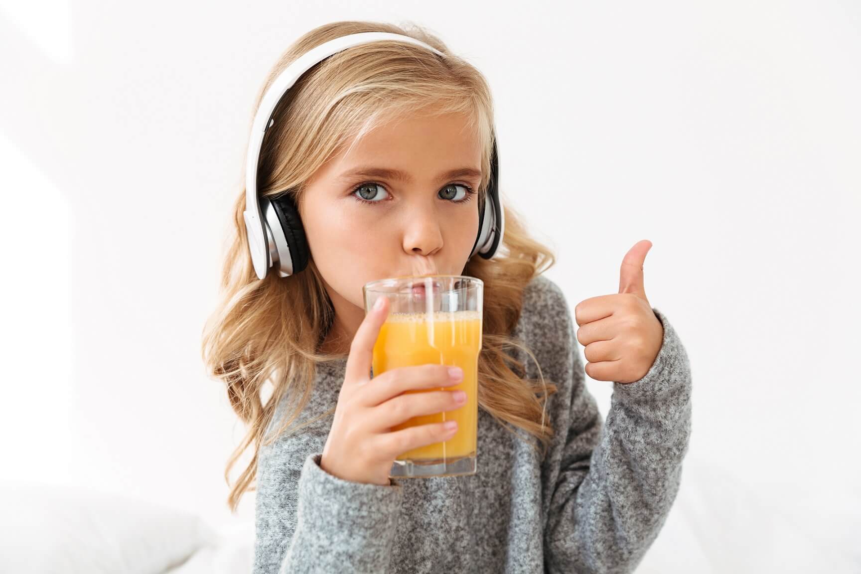 close-up-portrait-cute-girl-headphones-drinking-orange-juice-showing-thumb-up-gesture (1)