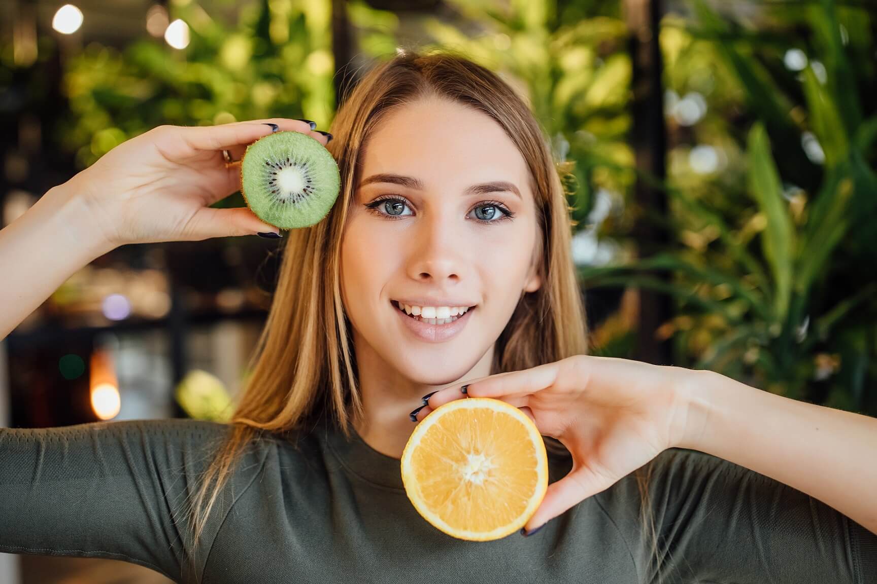 beautiful-young-blonde-woman-holding-piece-avocado-kiwi-front-her-eye-touching-her-face (1)